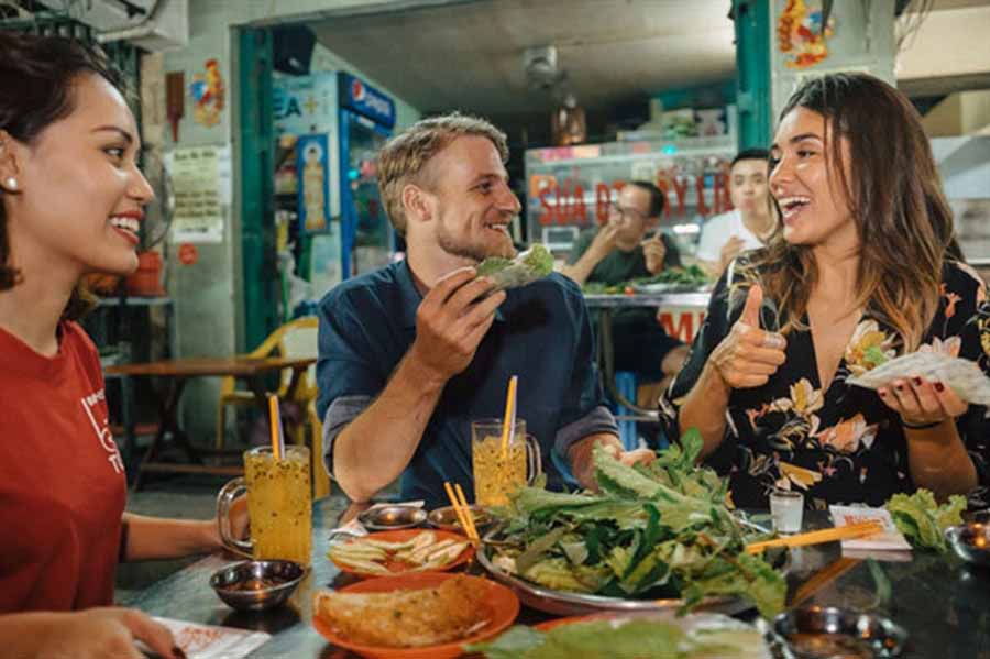 Tourists trying local fast food in Vietnam